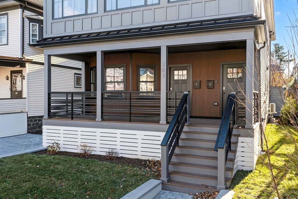 202 Powder House Boulevard, Unit 1 Somerville, MA 02144 - Photo 23 of 26 a view of a house with wooden fence and two windows