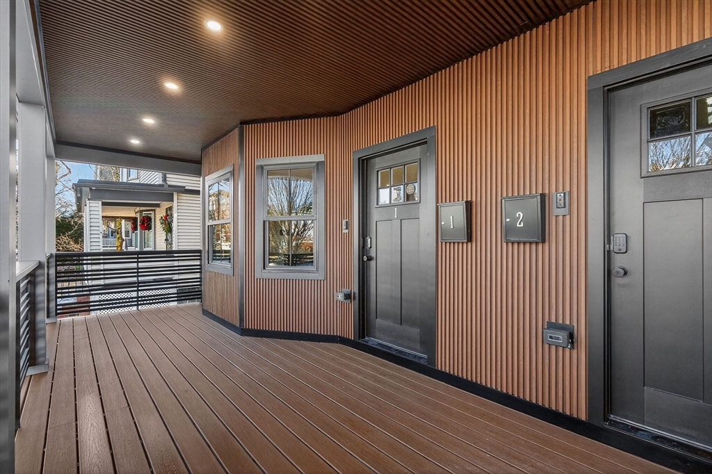 202 Powder House Boulevard, Unit 1 Somerville, MA 02144 - Photo 24 of 26 an empty room with wooden floor and windows