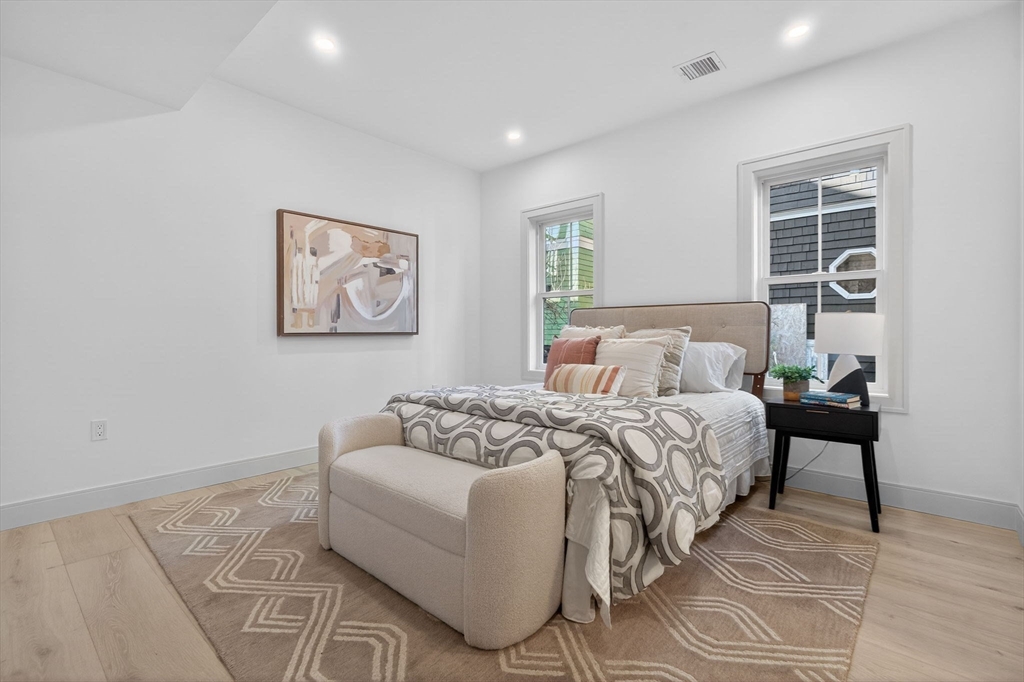 202 Powder House Boulevard, Unit 1 Somerville, MA 02144 - Photo 9 of 26 a bedroom with a bed and a window