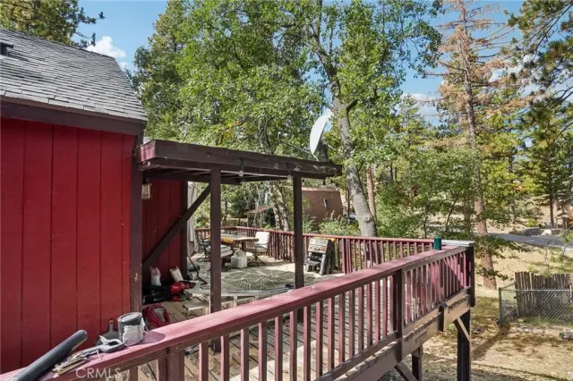 a view of a patio with a table chairs and a barbeque