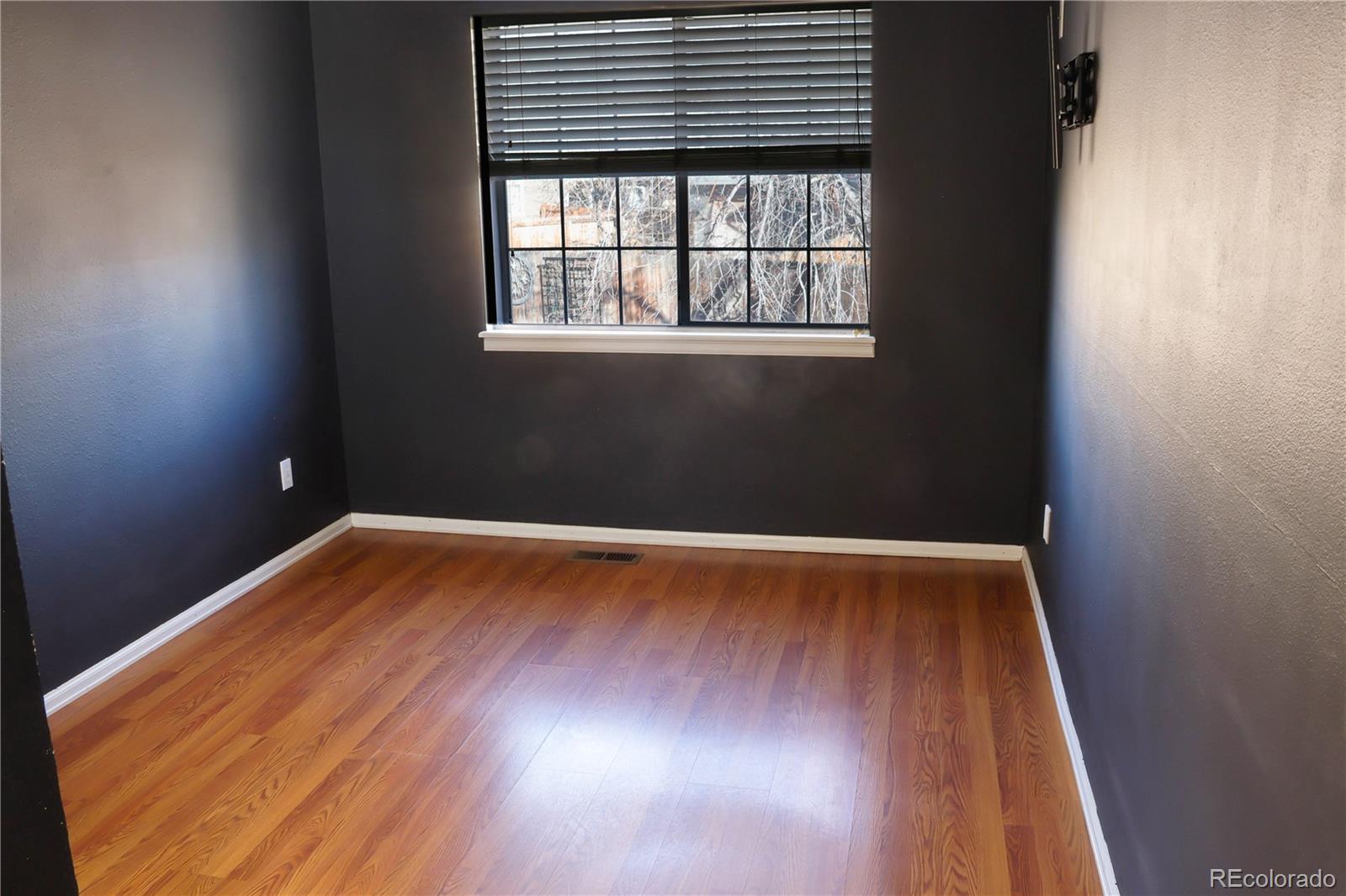4939 East 124th Way Thornton, CO 80241 - Photo 12 of 24 an empty room with wooden floor and windows