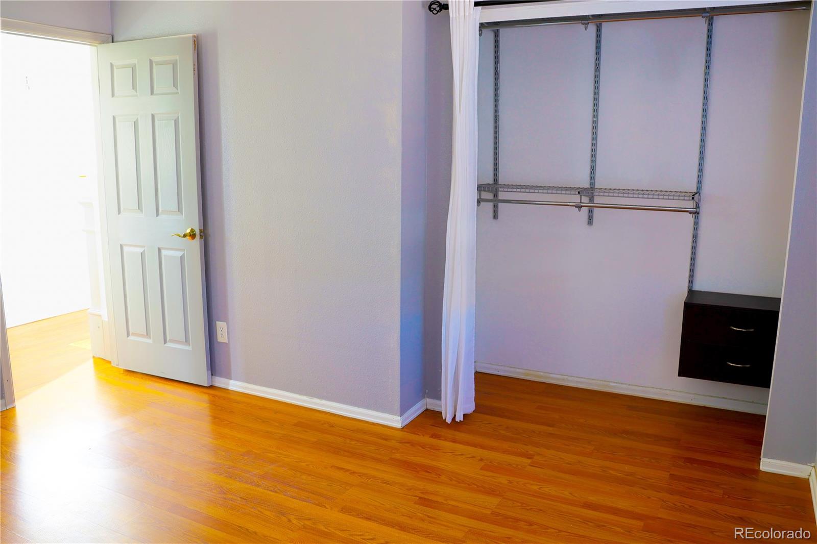 4939 East 124th Way Thornton, CO 80241 - Photo 10 of 24 a view of an empty room with wooden floor and closet