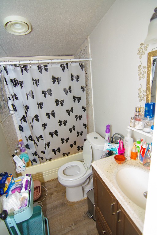 155 Arbuckle Road Elgin, TX 78621 - Photo 16 of 16 Full bathroom featuring vanity, light wood-style flooring, shower / bathtub combination with curtain, and a textured ceiling
