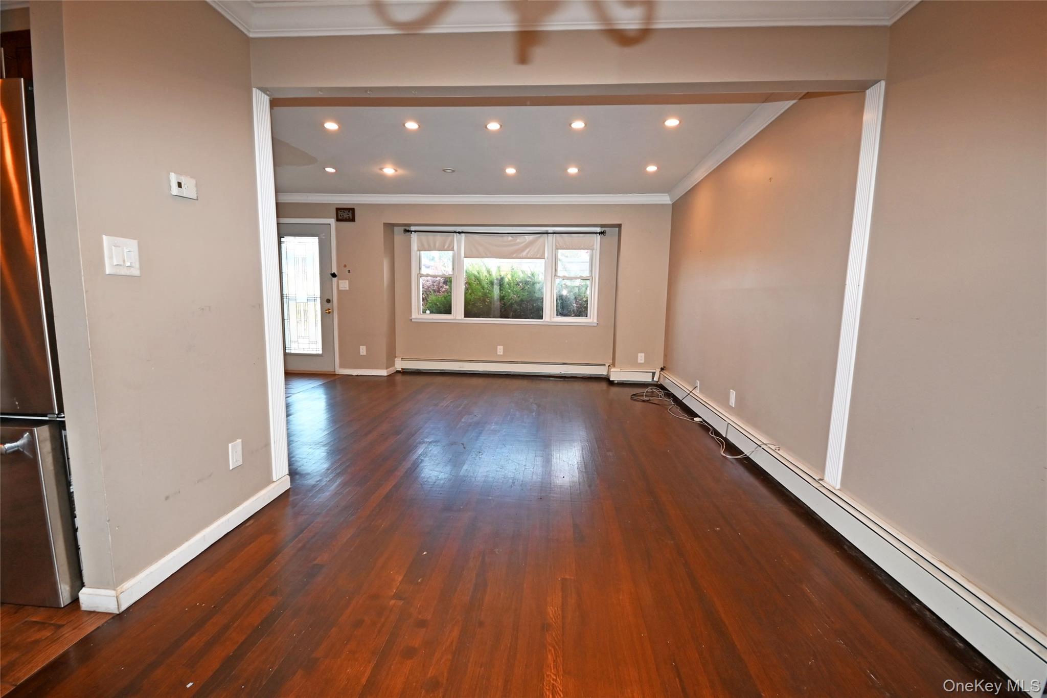 89 Osborne Road West Hempstead, NY 11552 - Photo 34 of 50 Unfurnished room featuring a baseboard heating unit, crown molding, dark wood finished floors, and recessed lighting
