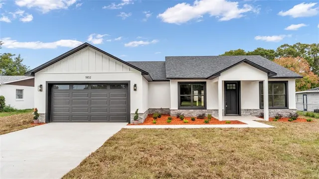a front view of a house with a yard outdoor seating and garage