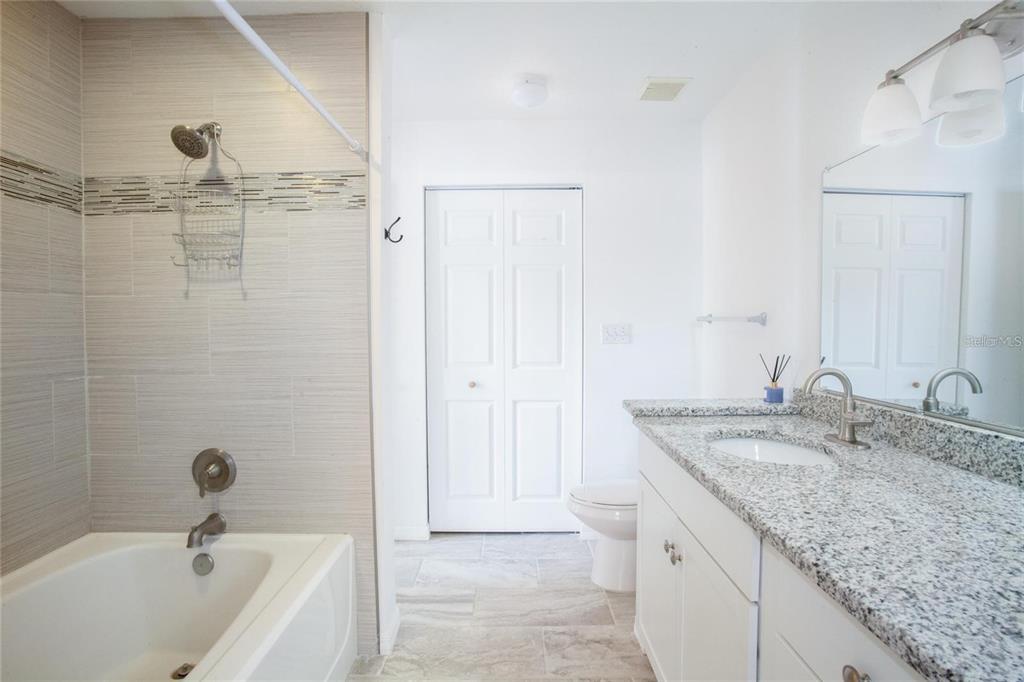 9704 Lake Chase Island Way, Unit 9704 Tampa, FL 33626 - Photo 11 of 23 a bathroom with a granite countertop sink and a mirror