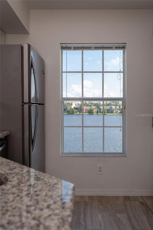 9704 Lake Chase Island Way, Unit 9704 Tampa, FL 33626 - Photo 16 of 23 a view of an empty room with wooden floor and a window