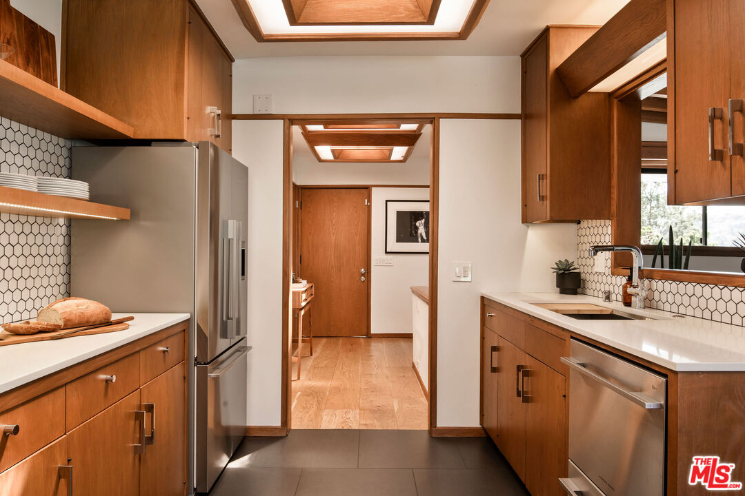 2371 Cove Avenue Los Angeles, CA 90039 - Photo 12 of 38 a kitchen with stainless steel appliances granite countertop a sink stove and refrigerator