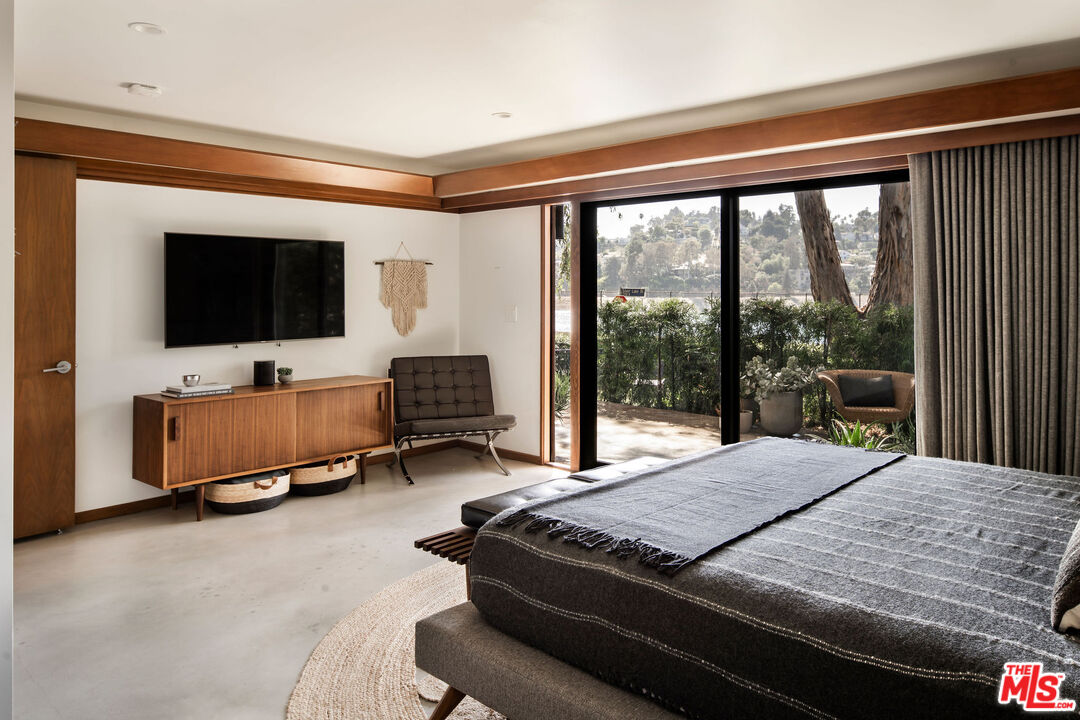 2371 Cove Avenue Los Angeles, CA 90039 - Photo 29 of 38 a bedroom with a bed and a flat tv screen next to a large window