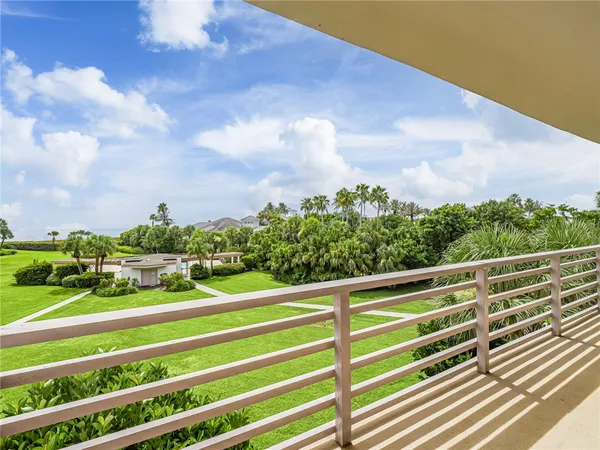a view of a green field with wooden fence