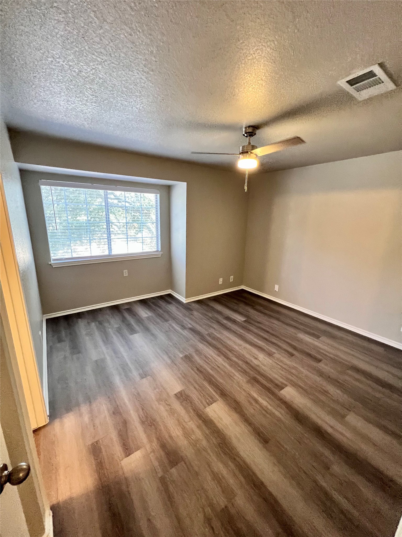 1801 Constantino Circle Austin, TX 78745 - Photo 14 of 22 an empty room with wooden floor fan and windows