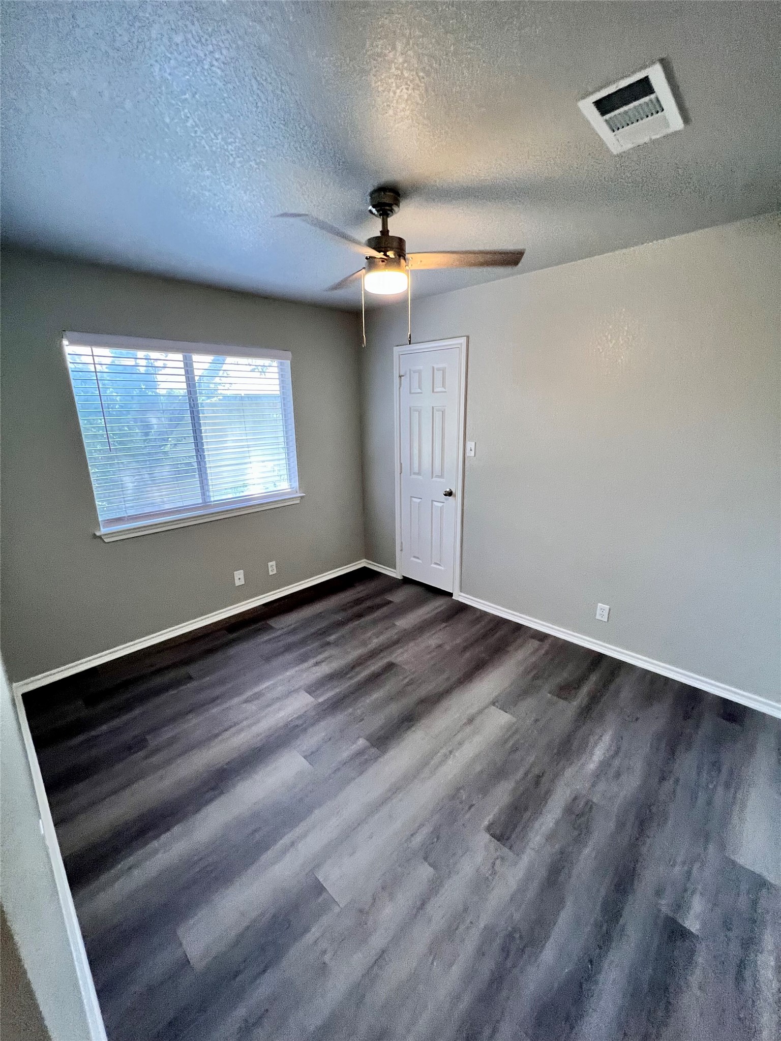 1801 Constantino Circle Austin, TX 78745 - Photo 20 of 22 an empty room with wooden floor ceiling fan and window