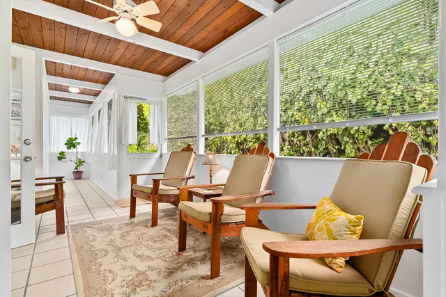 a living room with furniture and floor to ceiling windows