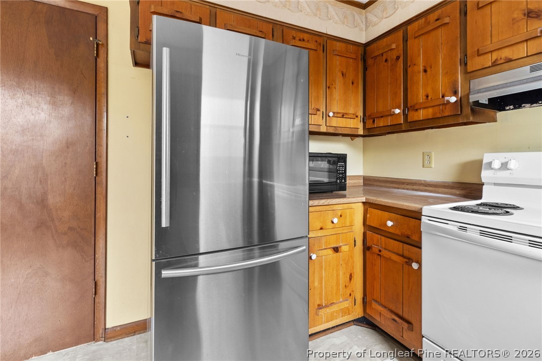 6009 Dalton Road Fayetteville, NC 28314 - Photo 16 of 36 a kitchen with stainless steel appliances granite countertop a refrigerator a stove and a sink with cabinets