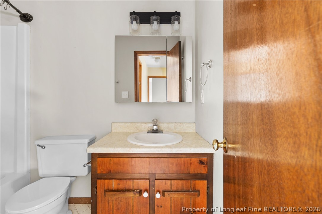 6009 Dalton Road Fayetteville, NC 28314 - Photo 25 of 36 a bathroom with a sink a toilet and a mirror