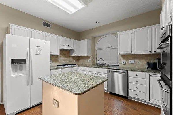 a kitchen with stainless steel appliances granite countertop a sink stove and refrigerator