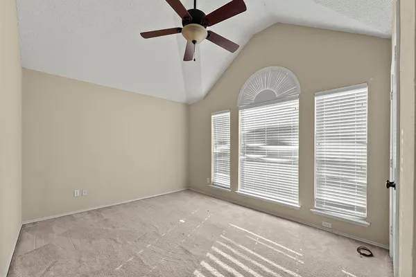 a view of a room with a ceiling fan and window