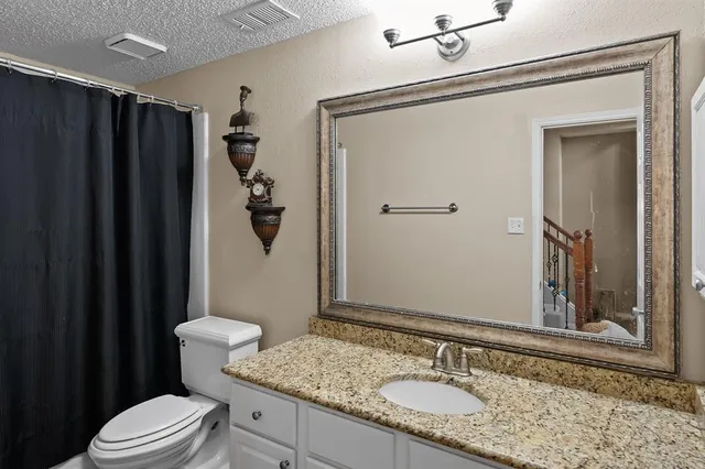 a bathroom with a granite countertop sink toilet and shower