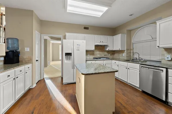 a kitchen with stainless steel appliances granite countertop a sink stove and refrigerator