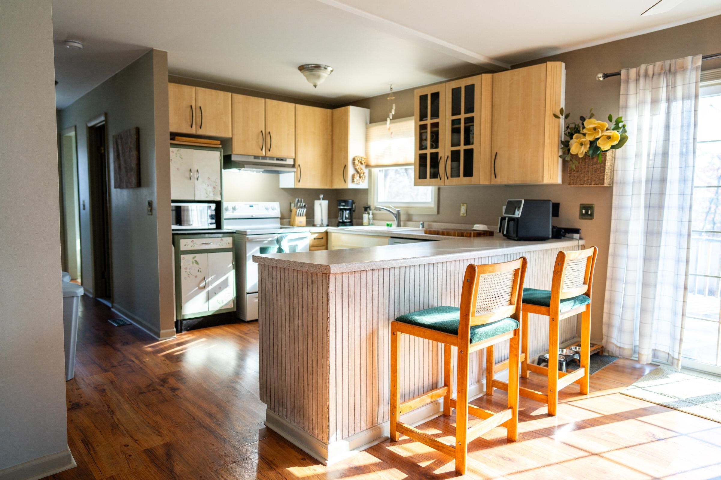 237 Rochester Road Northeast Poplar Grove, IL 61065 - Photo 10 of 28 a kitchen with stainless steel appliances granite countertop a refrigerator a stove a sink dishwasher and white cabinets with wooden floor