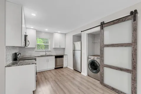 a kitchen with a refrigerator and a stove top oven