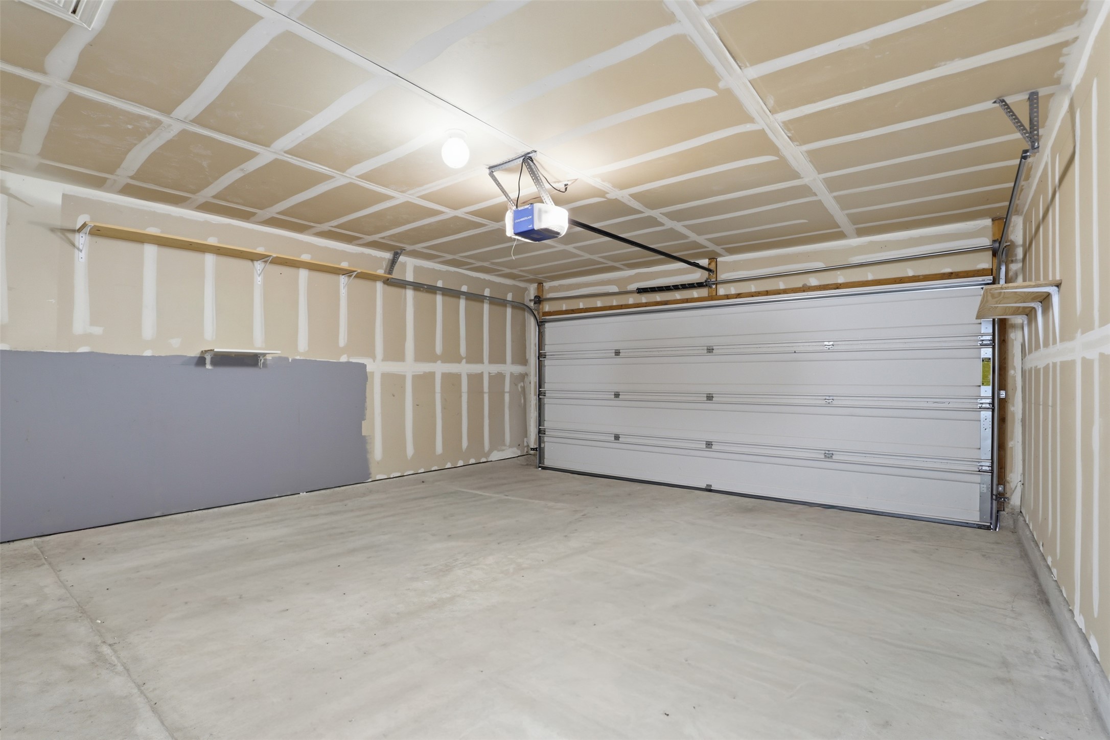 448 Nottingham Loop Kyle, TX 78640 - Photo 14 of 16 Spacious garage with a concrete floor and an overhead garage door