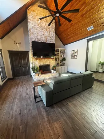 a living room with furniture a flat screen tv and a fireplace