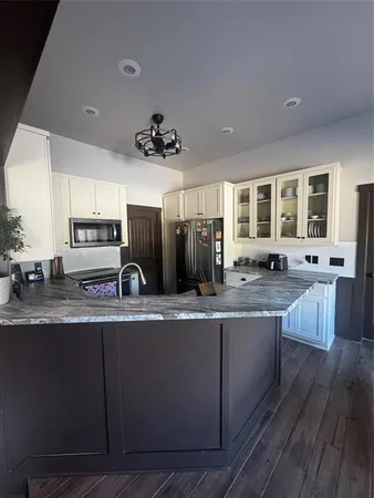 a large kitchen with stainless steel appliances a sink dishwasher a stove refrigerator and cabinets