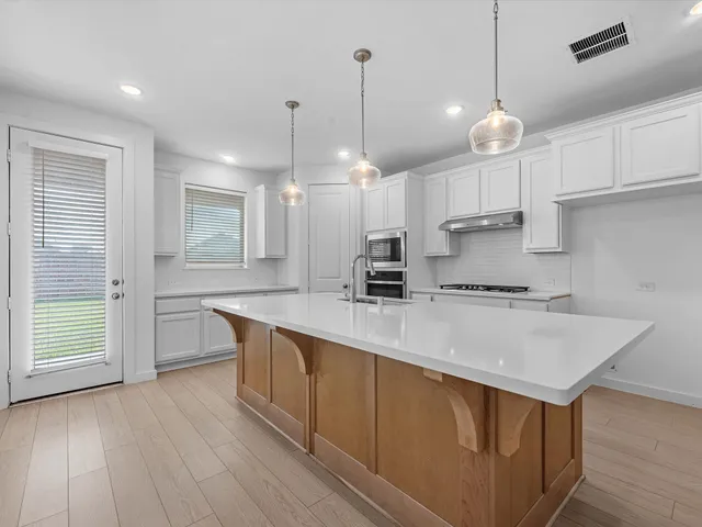 a kitchen with stainless steel appliances granite countertop a stove and a microwave