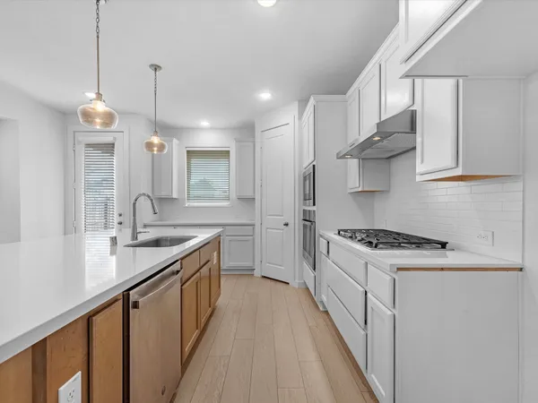 a kitchen with stainless steel appliances granite countertop a sink stove and cabinets