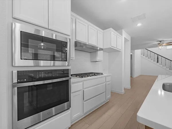 a kitchen with stainless steel appliances granite countertop a stove and a microwave