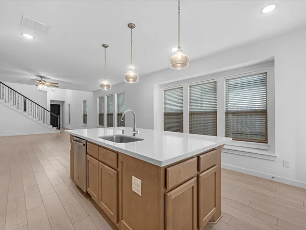 a hall with kitchen island a stove a sink and a large window