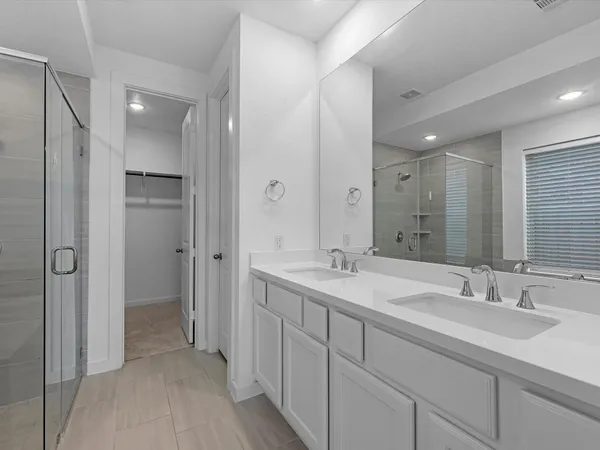 a bathroom with a double vanity sink mirror and shower