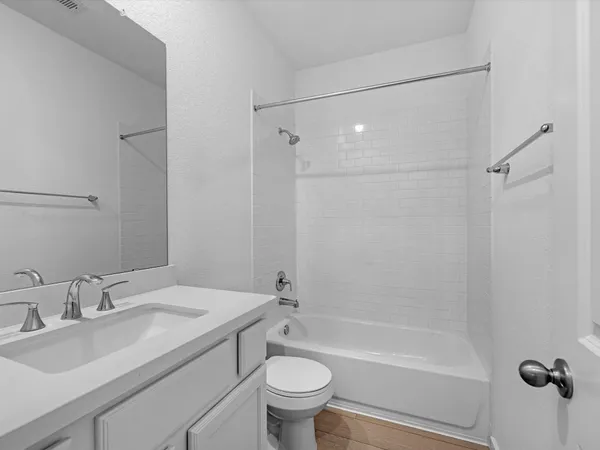 a bathroom with a granite countertop sink a toilet and shower