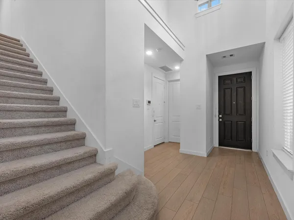 a view of a hallway with wooden floor and entryway