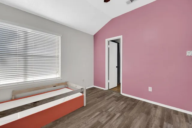 a spacious bedroom with a bed and a window