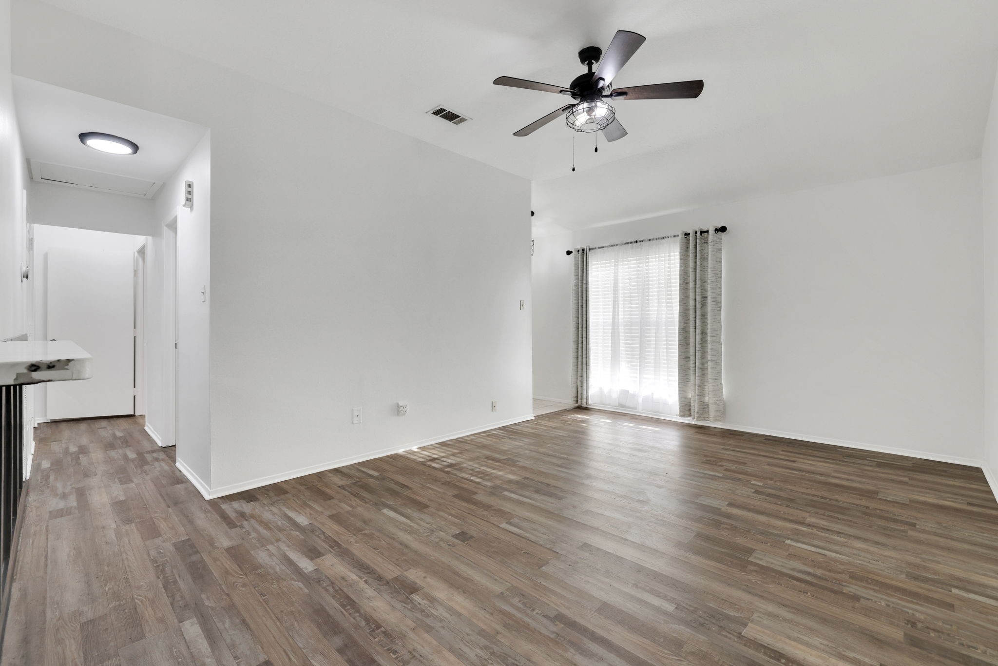 109 Jessica Street Liberty, TX 77575 - Photo 2 of 21 wooden floor in an empty room with a window