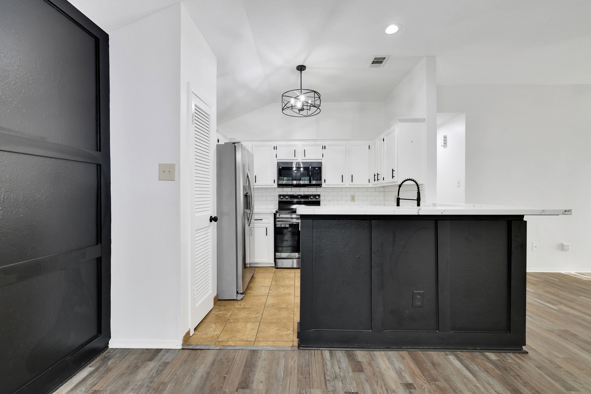 109 Jessica Street Liberty, TX 77575 - Photo 7 of 21 a kitchen with stainless steel appliances granite countertop a refrigerator a sink dishwasher and wooden cabinets with wooden floor