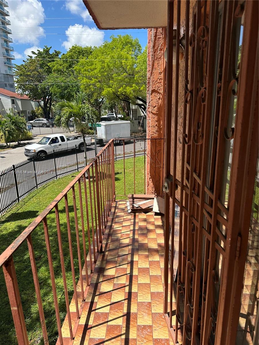 a view of balcony with wooden floor and fence