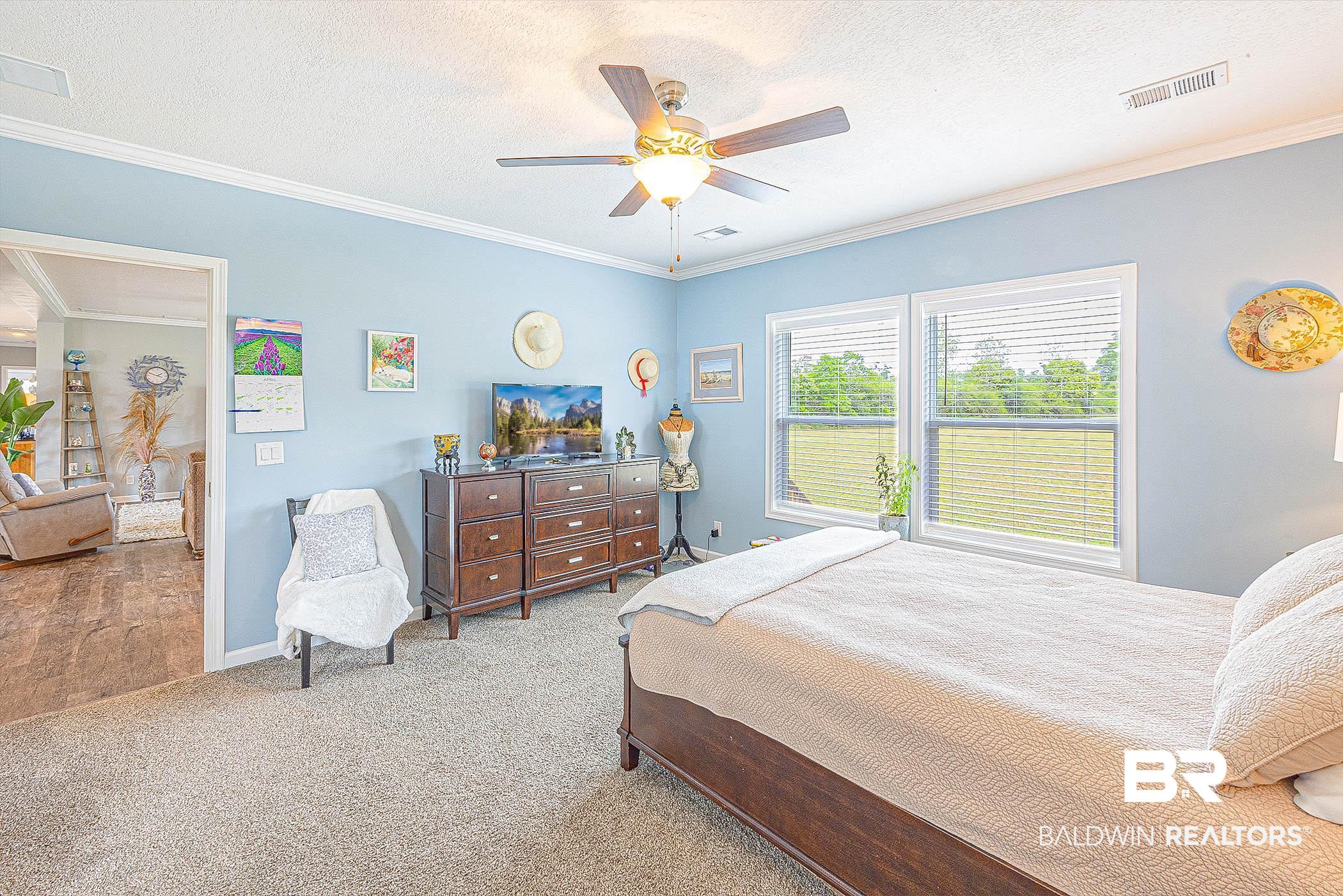 16000 John Bauer Road Summerdale, AL 36580 - Photo 19 of 34 Bedroom featuring a textured ceiling, ornamental molding, and visible vents