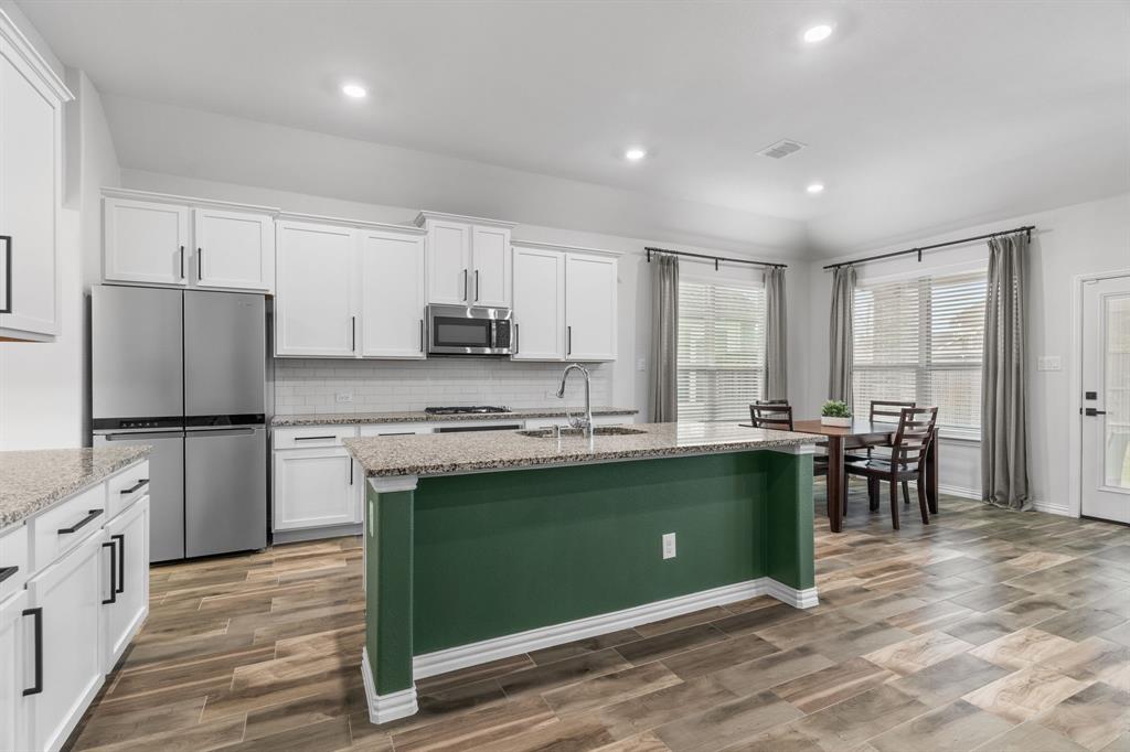 4324 Coffee Mill Road Celina, TX 75078 - Photo 11 of 38 a kitchen with stainless steel appliances granite countertop a stove refrigerator sink and cabinets