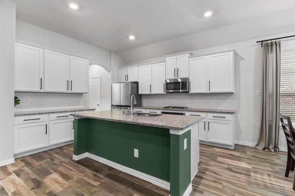 4324 Coffee Mill Road Celina, TX 75078 - Photo 12 of 38 a kitchen with stainless steel appliances granite countertop a stove a sink and a refrigerator