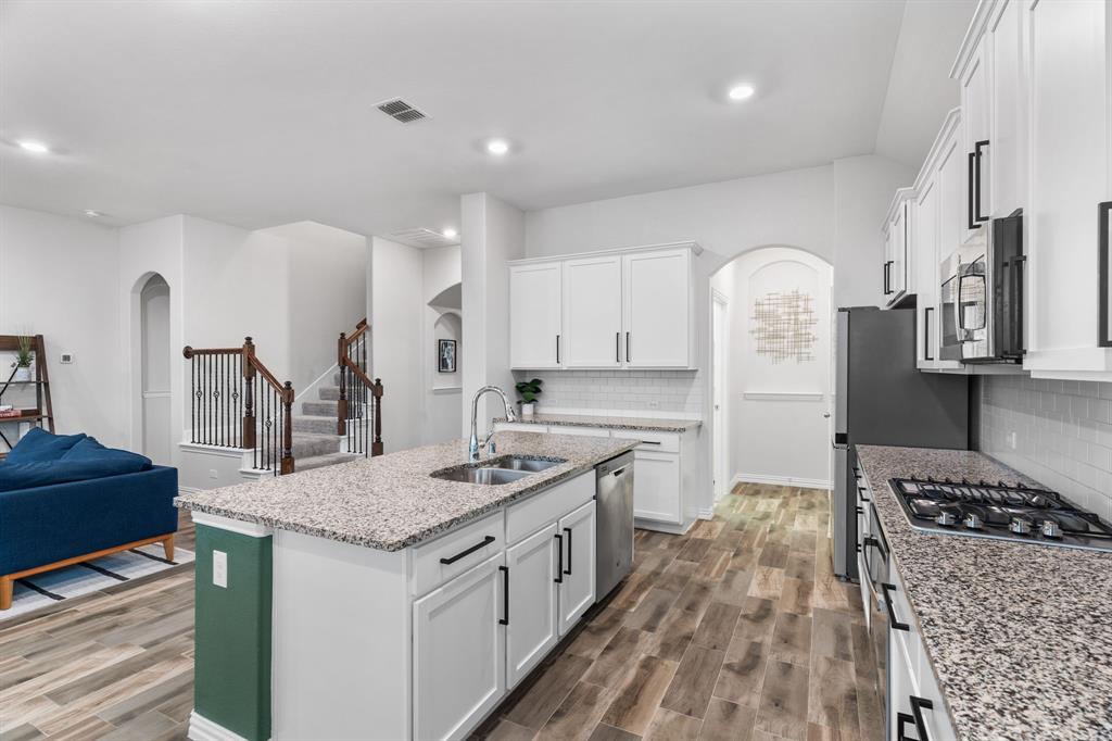 4324 Coffee Mill Road Celina, TX 75078 - Photo 15 of 38 a kitchen with stainless steel appliances granite countertop a stove and a refrigerator