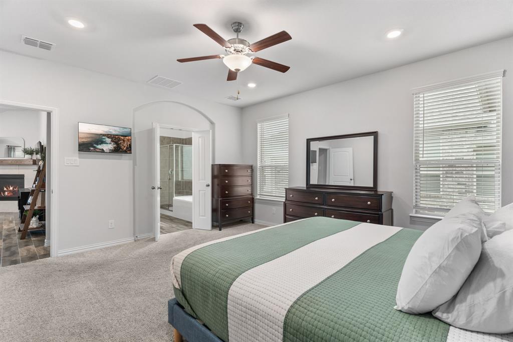 4324 Coffee Mill Road Celina, TX 75078 - Photo 19 of 38 a bedroom with a large bed and a chandelier