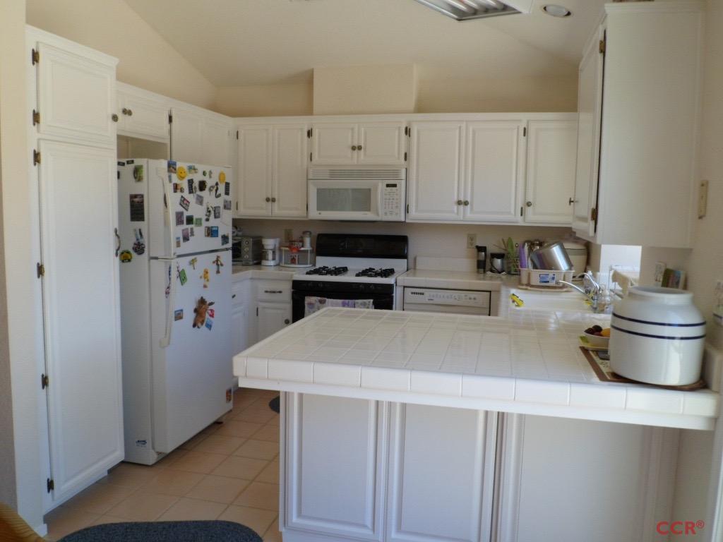 1434 Roper Way Santa Maria, CA 93455 - Photo 6 of 18 a kitchen with a refrigerator and white cabinets