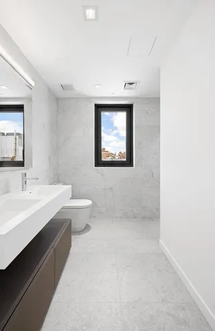 a bathroom with a double vanity sink toilet and mirror