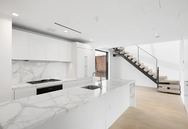 a kitchen with granite countertop a white stove top oven and sink