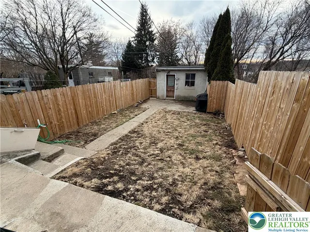 a view of a backyard with a fence