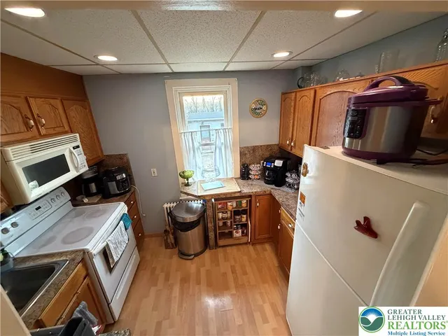 a kitchen with a refrigerator a stove top oven a sink dishwasher and wooden floor