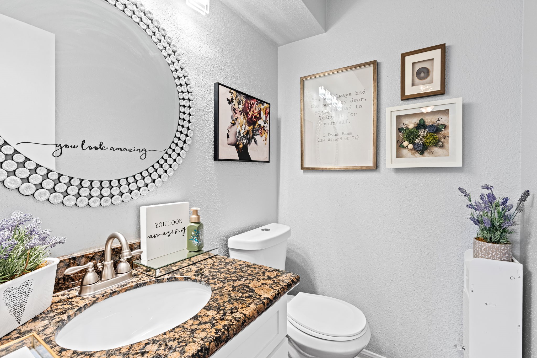 2211 South Kirkwood Road, Unit 1 Houston, TX 77077 - Photo 9 of 16 The powder bath makes no attempt to blend in — an oversized round mirror with a crystal bubble frame fills most of the wall above a dark speckled granite vanity, turning a half bath typically treated as an afterthought into one of the more distinctive rooms on the first floor.